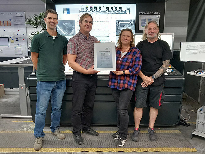 Patrick Cunningham (SID), Lars Maßlow (Möller Pro Media), Carolin Sommerer (SID) und Norbert Lathan (Möller Pro Media) mit der neuen PSO-Urkunde der Möller Pro Media GmbH pm-sid-pso-moeller