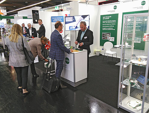 Visitors engaged in discussions with the PITSID stand staff